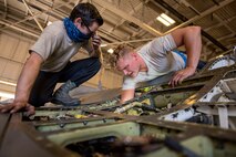 Airman 1st Class Gabriel Leal, 311th Aircraft Maintenance Unit avionics journeyman, watches as Senior Airman Brian Raatz, 311th AMU F-16 Viper crew chief, inspects wiring on an aircraft, June 4, 2020, on Holloman Air Force Base, N.M. Three Airmen from the 311th AMU are replacing 11 wire harnesses throughout the plane that range up to 90 feet of wiring, which can take up to three months to repair. (U.S. Air Force photo by Staff Sgt. Christine Groening)