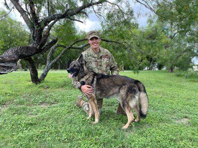 A military working dog handler who trains students from the Air  Force poses for a photo following participation in a K-9 demonstration for the Fair Oaks, Texas, Rotary Club June 3, 2020, at Joint Base San Antonio-Lackland.