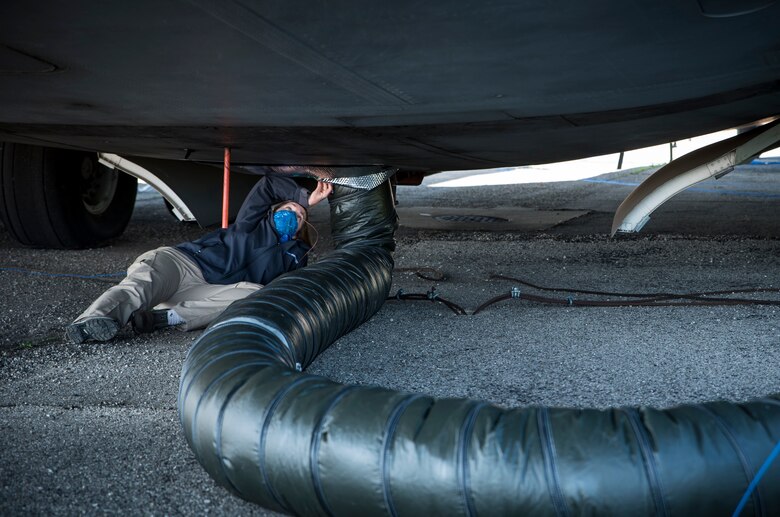 Dr. Angela Theys of Materials Engineering and Technical Support Services secures ductwork for an Air Force Research laboratory test to investigate the use of ground heaters to raise interior temperatures on C-17 aircraft. This test is part of an overall effort to demonstrate the effectiveness of using common equipment to heat aircraft to COVID-19 disinfection temperatures quickly and easily at virtually any military installation. (U.S. Air Force photo/Richard Eldridge)