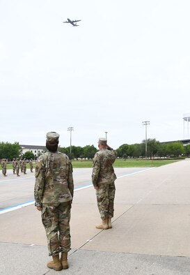 U.S. Air Force Col. Heather Blackwell, 81st Training Wing commander, and Chief Master Sgt. David Pizzuto, 81st TRW command chief, watch a C-130J Hercules conduct a fly-over in honor of Pizzuto's retirement on the Levitow Training Support Facility drill pad at Keesler Air Force Base, Mississippi, May 15, 2020. Pizzuto retires with 37 years of military service. (U.S. Air Force photo by Kemberly Groue)