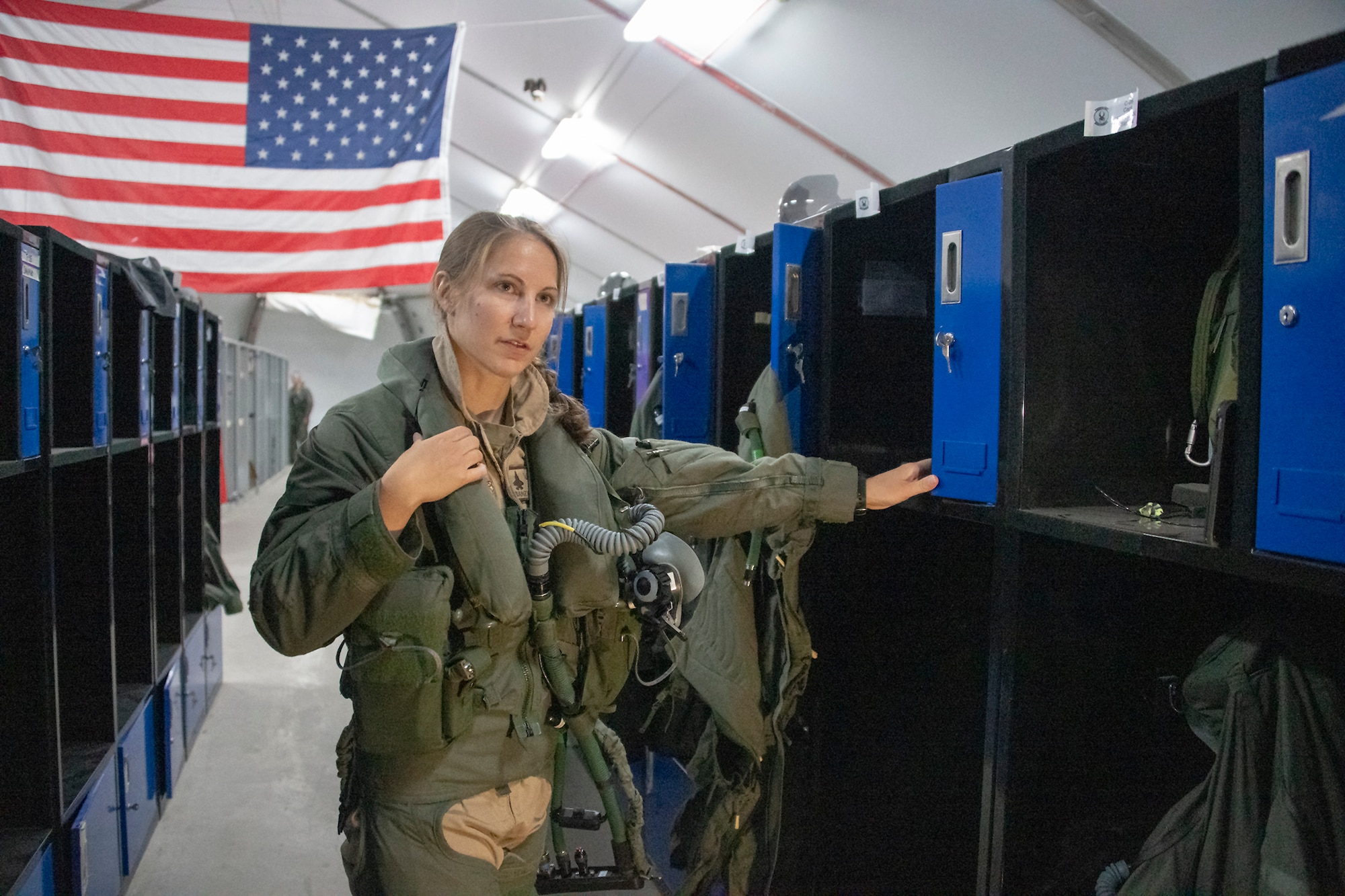 U.S. Air Force Capt. Emily Thompson, 421st Expeditionary Fighter Squadron pilot, dons flight equipment at the Aircrew Flight Equipment shop on Al Dhafra Air Base, United Arab Emirates, June 5, 2020. Thompson is the first female to fly an F-35A Lightning II into combat. She is currently deployed from Hill Air Force Base, Utah. (U.S. Air Force photo by Tech. Sgt. Kat Justen)