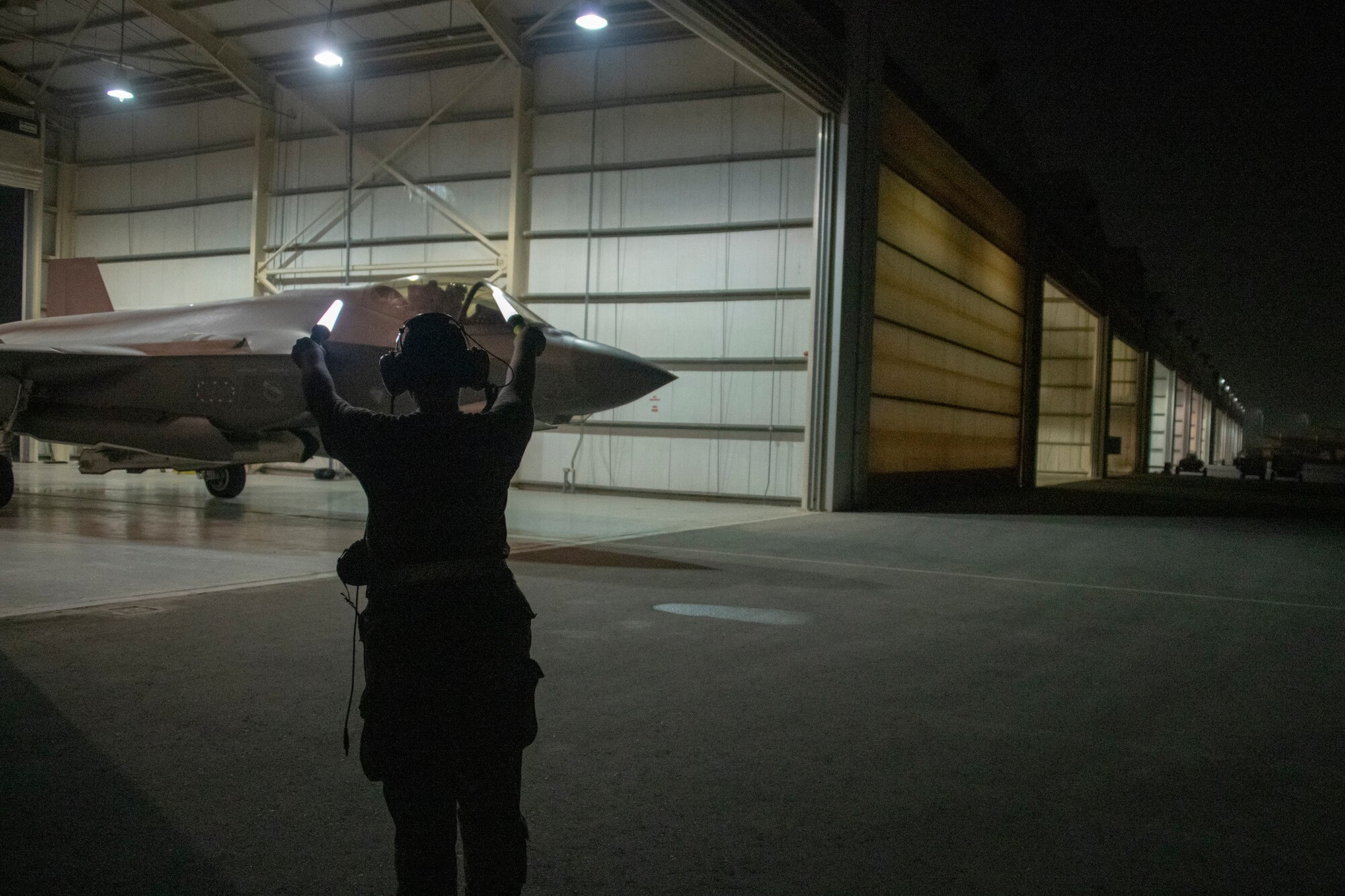 U.S. Air Force Capt. Emily Thompson, 421st Expeditionary Fighter Squadron pilot, launches an F-35A Lightning II while Airman 1st Class Ashlin Randolph, a 380th Aircraft Maintenance Squadron weapons load crew member, gives the signal to proceed on the Al Dhafra Air Base, United Arab Emirates, flightline June 5, 2020.Thompson is the first female to fly an F-35A Lightning II into combat. She was also launched by an all-female maintenance crew.  (U.S. Air Force photo by Tech. Sgt. Kat Justen)