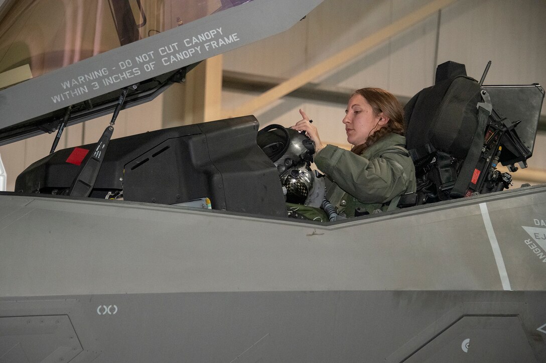 U.S. Air Force Capt. Emily Thompson, 421st Expeditionary Fighter Squadron pilot, dons her helmet prior to a mission at Al Dhafra Air Base, United Arab Emirates, June 5, 2020. Thompson is the first female to fly an F-35A Lightning II into combat. She is currently deployed from Hill Air Force Base, Utah. (U.S. Air Force photo by Tech. Sgt. Kat Justen)