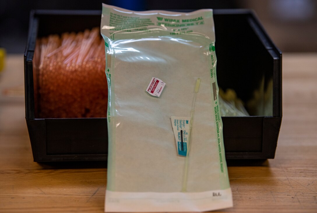 Nasopharyngeal swabs for COVID-19 testing rests at a workstation.