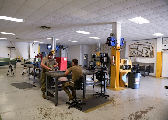 Tech. Sgts. Ryan McBride, 19th Maintenance Squadron NCO in charge of metals technology, and Jason Felts, 19th Maintenance Squadron sheet metal production lead, prepare a new 3D printed hydraulic pump bracket for installation at Little Rock Air Force Base, Arkansas, June 4, 2020. 3D printing the bracket will make it easier for C-130J maintenance units across the Air Force to obtain the part and eliminate the need to manufacture the part themselves. (U.S. Air Force photo by Airman 1st Class Jayden Ford)