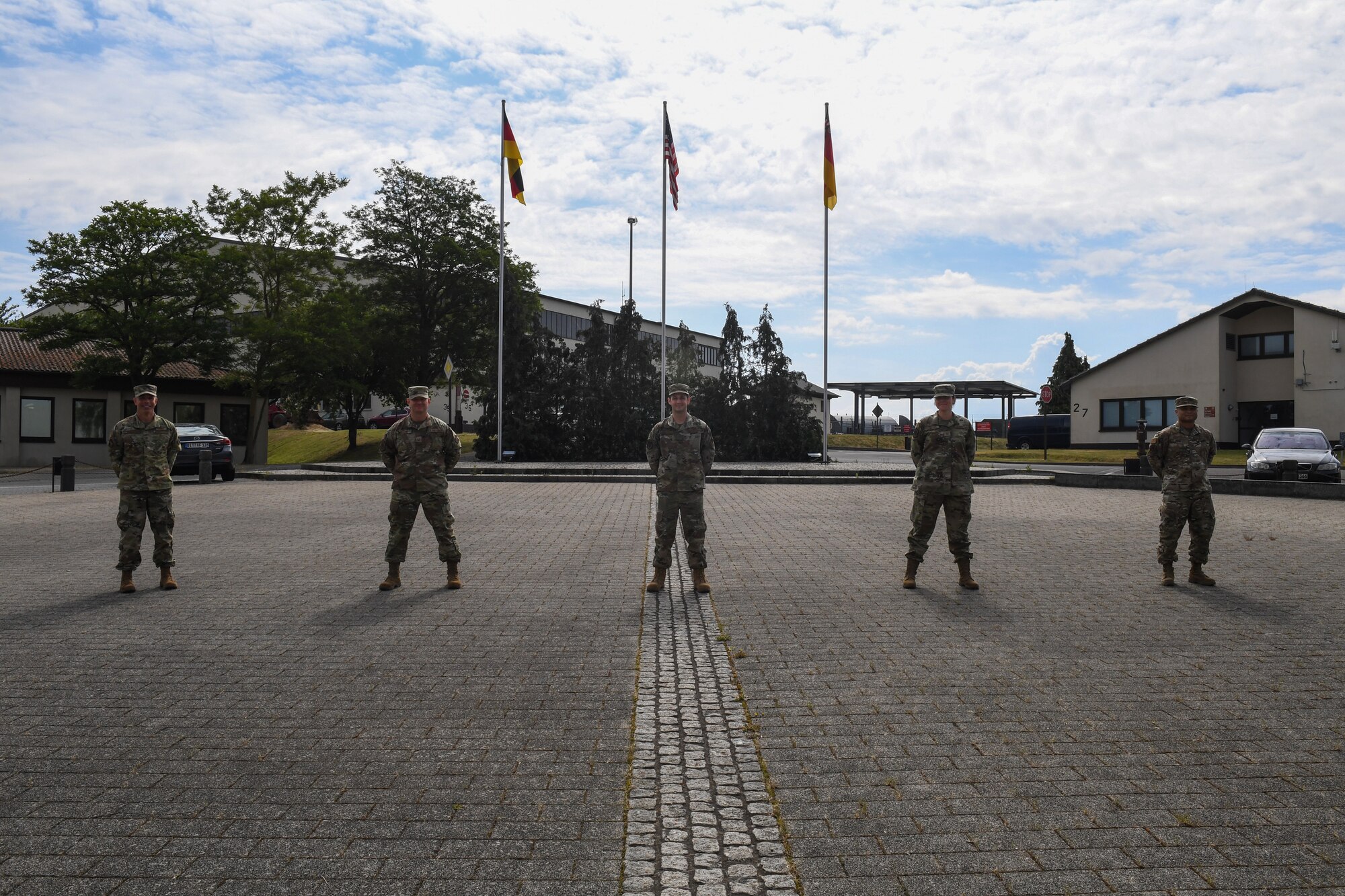 U.S. Air Force Senior Airman Ryan Amador, 52nd Maintenance Squadron Air Force repair enhancement program technician, center, poses for a photo after being coined by the 52nd FW vice commander, U.S. Air Force Col. Jason Hokaj, far left, at Spangdahlem Air Base, Germany, June 8, 2020. Amador was awarded with the commander's innovation coin for his efforts in establishing a new entry contol point on the flightline. (U.S. Air Force photo by Airman 1st Class Alison Stewart)