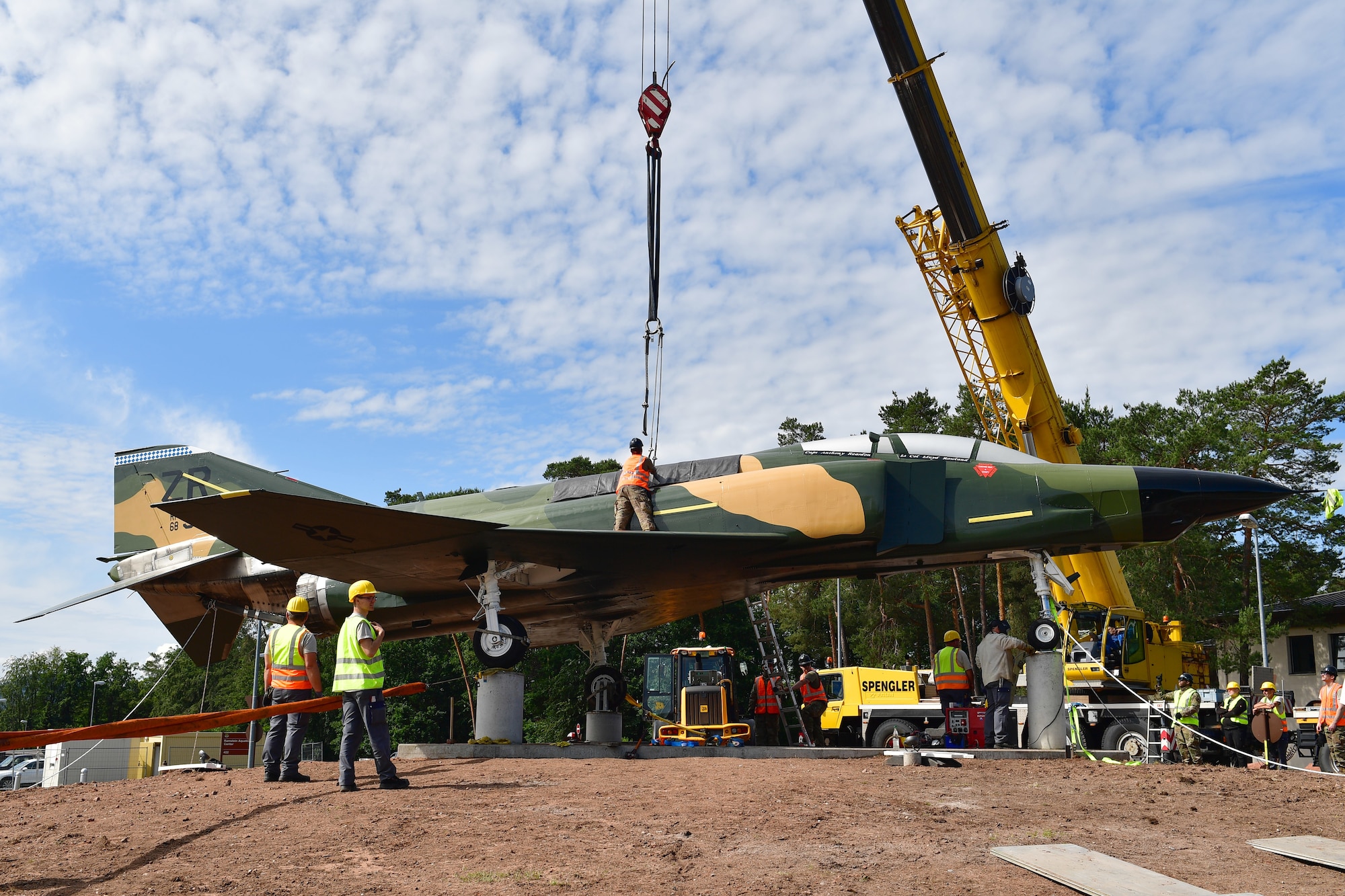 Workers install an aircraft for static display.