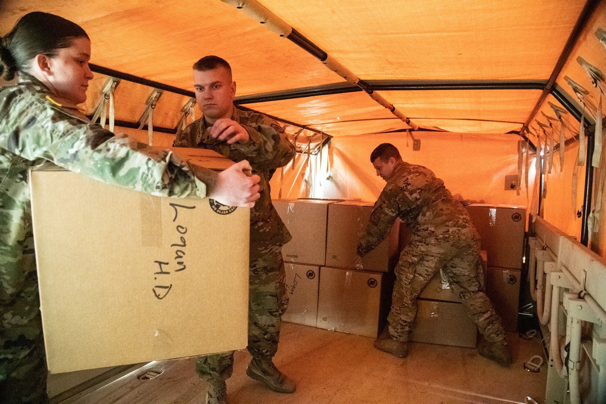 Members of the West Virginia National Guard help process and deliver medical supplies to hospitals, clinics and local health departments throughout West Virginia in COVID-19 pandemic response efforts, March 24, 2020, in Poca, West Virginia. Workers packaged surgical masks, respirators, sterile gowns and gloves for delivery around the state. (Photo by Edwin Wriston)