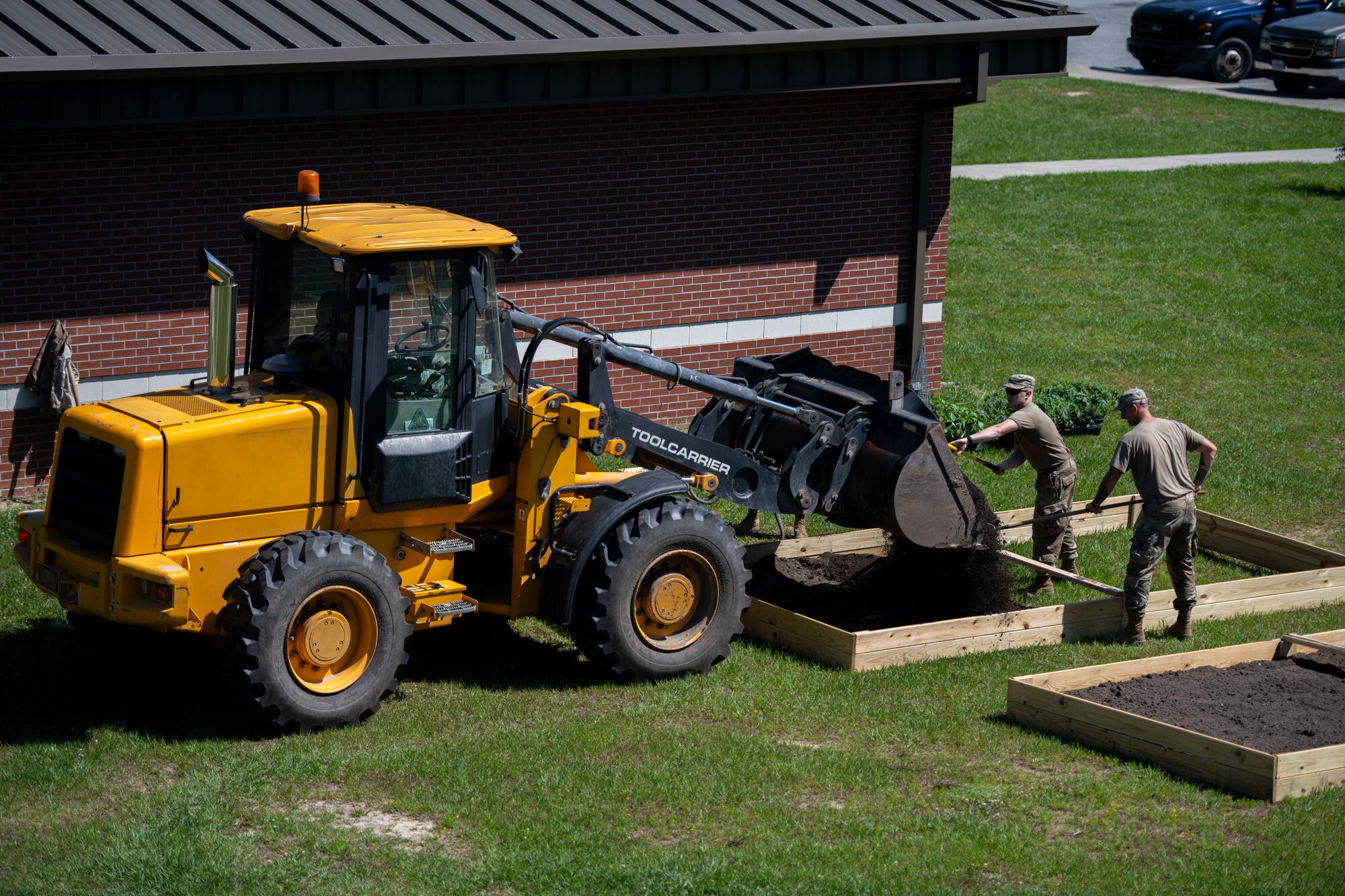 Airmen assigned to the 4th Civil Engineer Squadron dispense dirt in a garden plot at Seymour Johnson Air Force Base, N.C. on June 1, 2020.