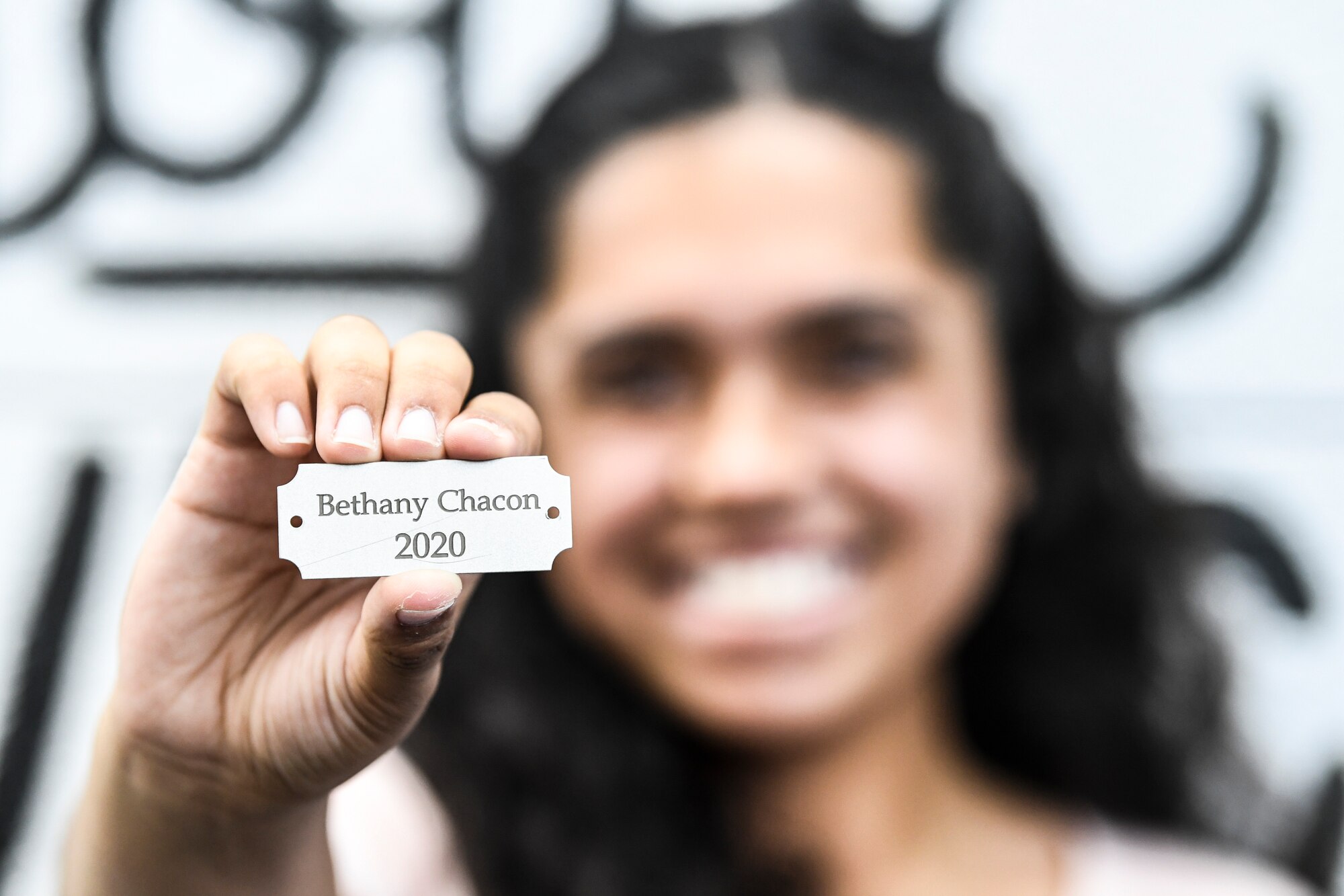 A girl holds her nameplate.