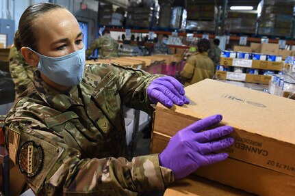 Airman 1st Class Alicia Day, 194th Intelligence Squadron, packs food boxes at the Nourish Food Bank warehouse April 3, 2020 in Lakewood, WA. Day is one of more than 40 Washington Air National Guardsmen who were activated on April 2, to support food banks across Washington state as part of the state’s COVID-19 response efforts.