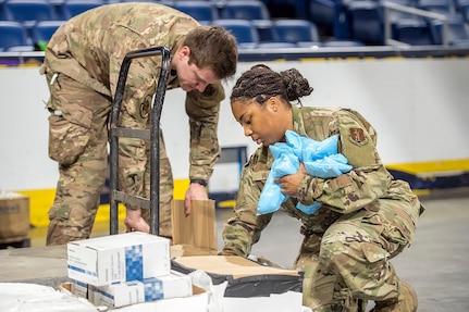 Louisiana Air National Guard Staff Sgt. Logan Decker and Senior Airman Elexius Green and Senior Airmen Leyah Hills sort medical supplies at the Smoothie King Center, New Orleans, La. on March 31, 2020. Medical supplies from various Federal, State and City agencies are being stored at the sports arena before being distributed to drive-through community based COVID-19 testing sites located in Orleans and Jefferson Parishes.