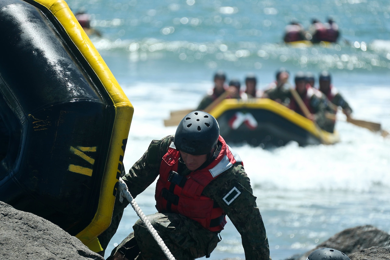 Navy SEAL candidates perform rock portage.