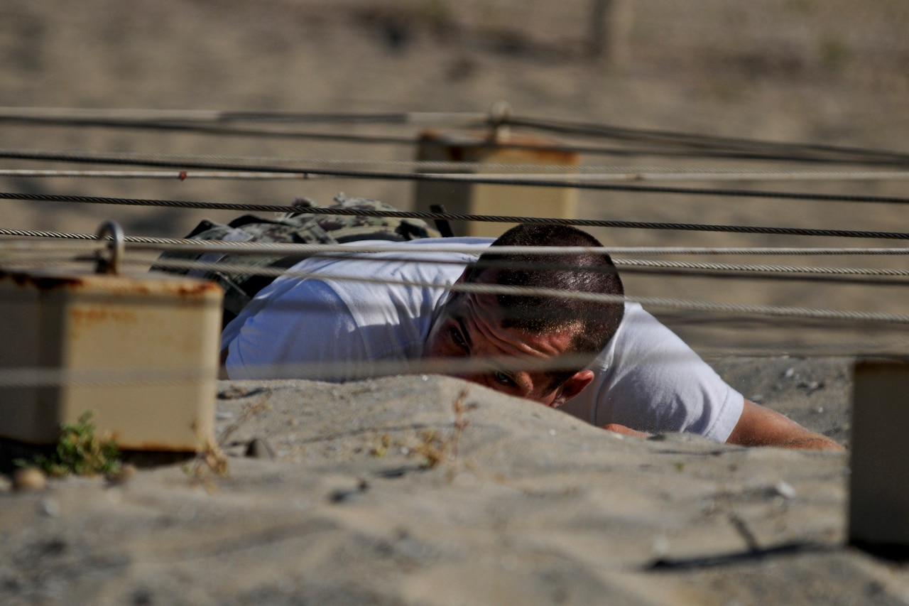 Navy SEAL candidates navigate the obstacle course.