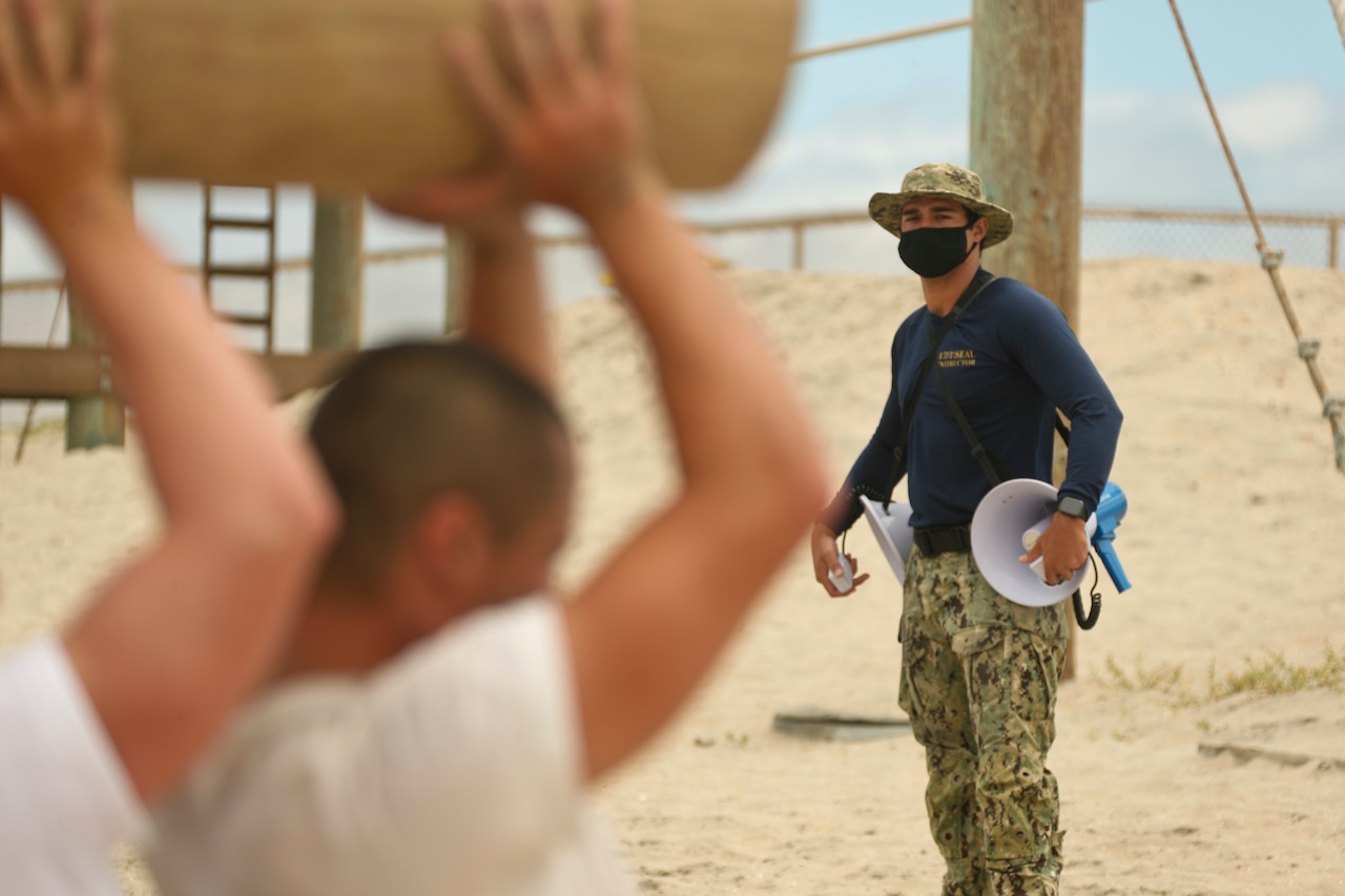 Navy SEAL candidates train with logs.