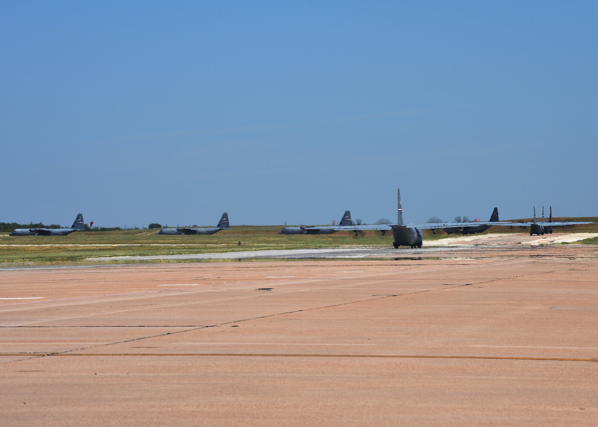 A line of C-130J Super Hercules taxi along the flightline at Dyess Air Force Base, Texas in preparation for an U.S. Air Force Weapons School Joint Forcible Entry exercise June 6, 2020. Approximately eight of Dyess’ aircraft took part in the exercise at Nellis AFB, Nev. (U.S. Air Force photo by Senior Airman Mercedes Porter)