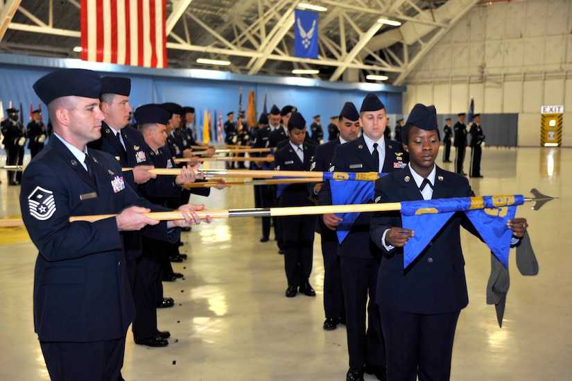Members of the 11th Wing furl and case the squadron and group guidons belonging to the 316th Wing during a 316th Wing to 11th Wing mission movement ceremony on Oct. 1, 2010, in Hangar 3 here.