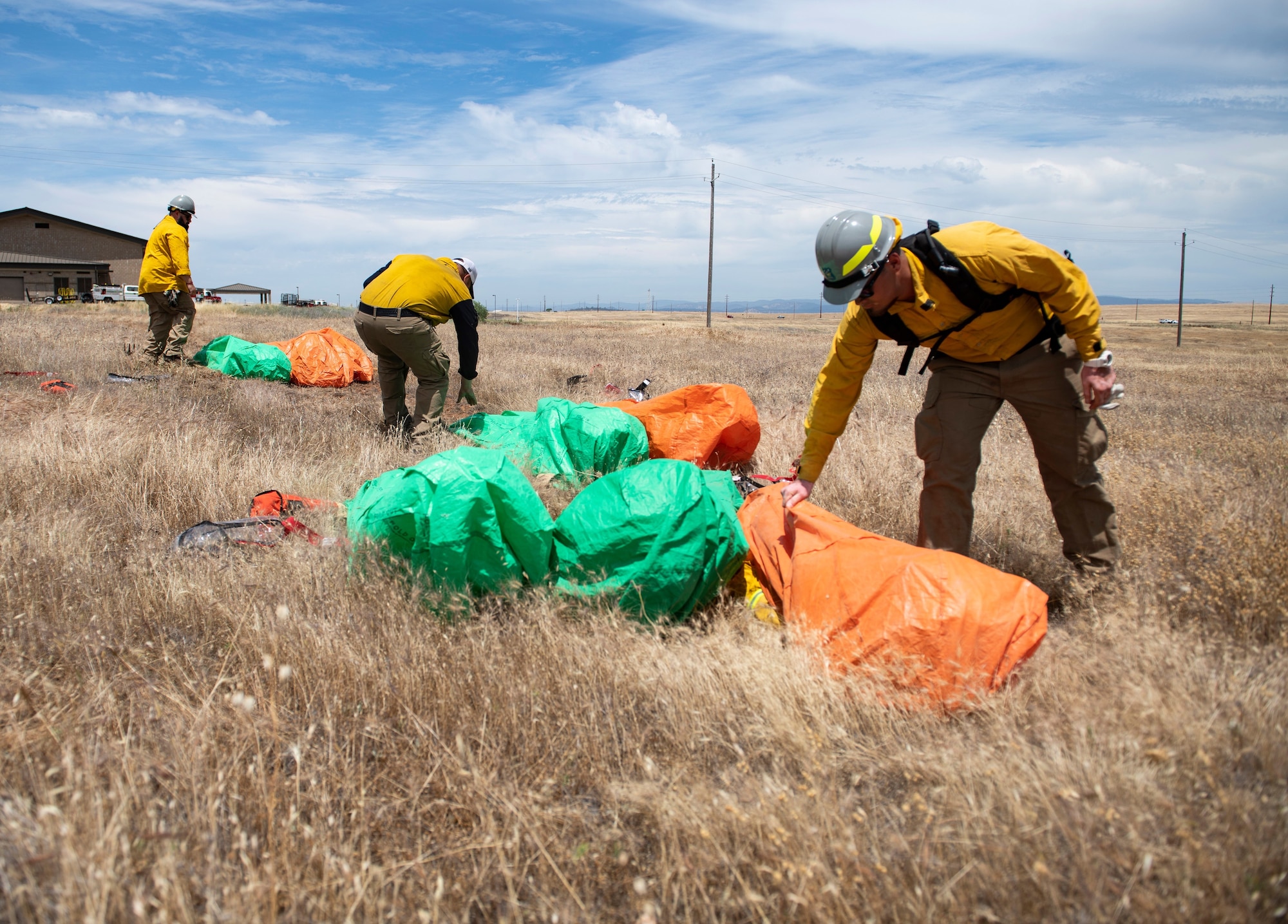 Instructors check how well 9th Civil Engineer Squadron firefighters deployed into their fire shelters.
