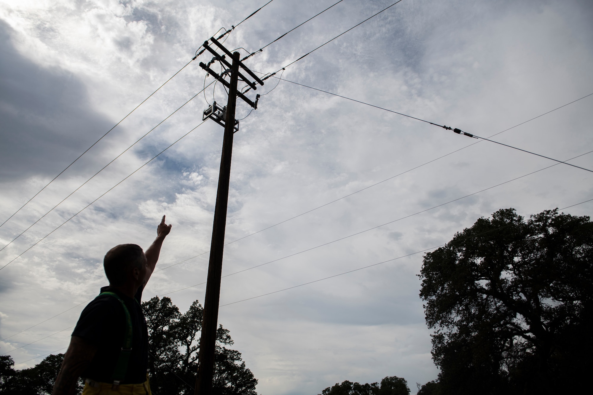 Dennis Reinhardt points to the suspected cause of the fire, a malfunctioned power line component