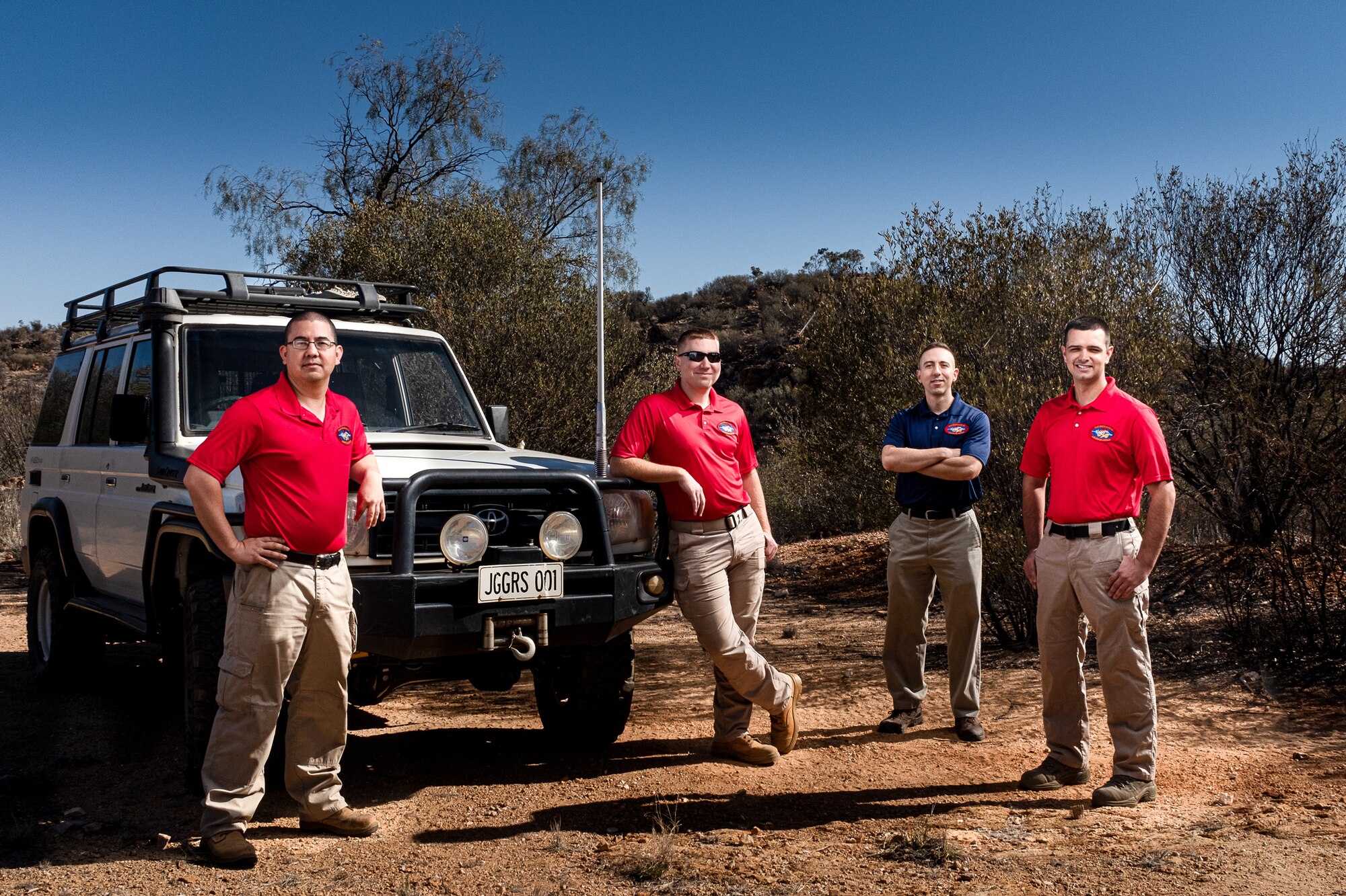 Airmen assigned to the 709th Technical Maintenance Squadron, Detachment 421, pose for a group photo in this composite image in Alice Springs, Australia, Aug. 28, 2019. The Airmen are responsible for maintaining a 20-sensor seismic array, which monitors vibrations in the Earth’s crust and can detect nuclear detonations. (U.S. Air Force photo illustration by Master Sgt. Benjamin Wilson)