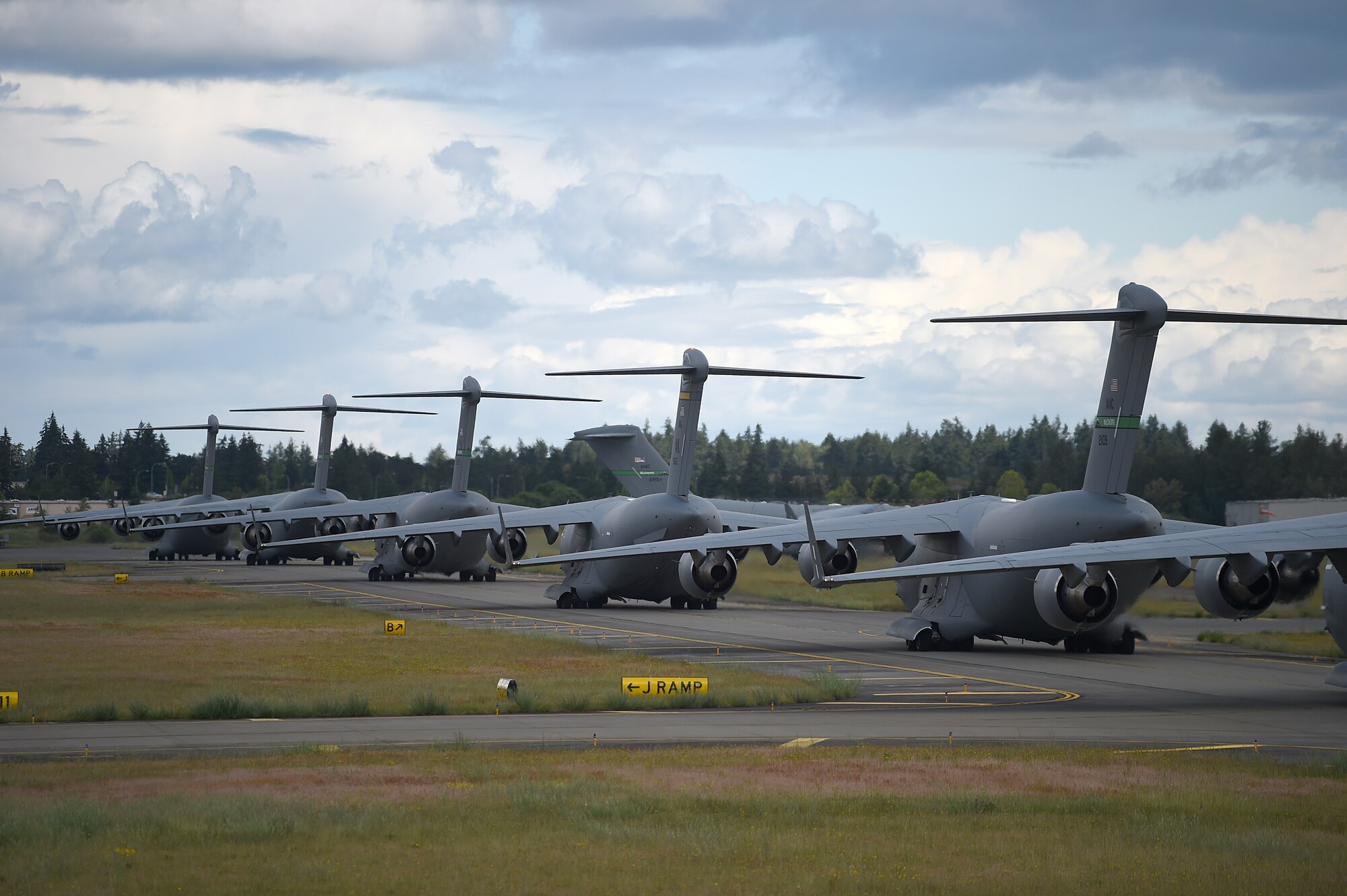 A formation of C-17 Globemaster IIIs from the 62nd Airlift Wing, 446th Airlift Wing, and Joint Base Elmendorf-Richardson, Alaska, prepare to take off from Joint Base Lewis-McChord, Wash., June 6, 2020. These aircraft made up a small portion of the 87 total that participated in a weapons instructor course joint force training exercise over the Nevada Test and Training Range. (U.S. Air Force photo by Airman 1st Class Mikayla Heineck)