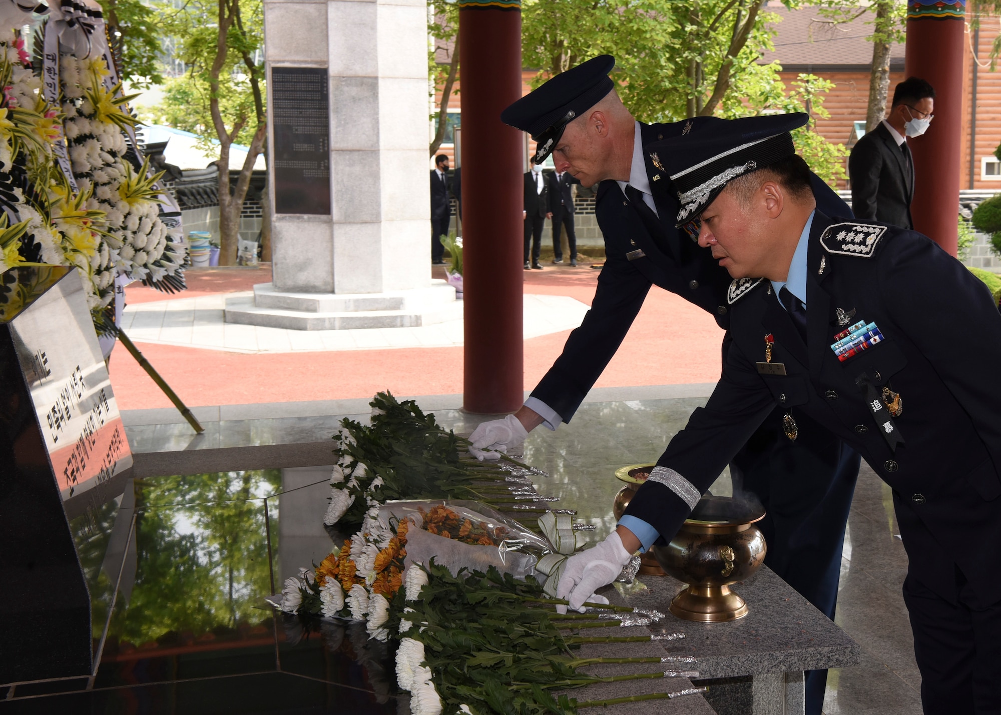 U.S. Air Force Col. Chris Hammond, 8th Fighter Wing commander, lays a white carnation to honor the fallen during the Korean Memorial Day ceremony at Gunsan City, Republic of Korea, June 6, 2020. The Korean citizens who died while serving in the military and those who lost their lives during the independence movement were honored with white carnations during the ceremony while flags and flowers were displayed at each headstone. (U.S. Air Force photo by Staff Sgt. Anthony Hetlage)