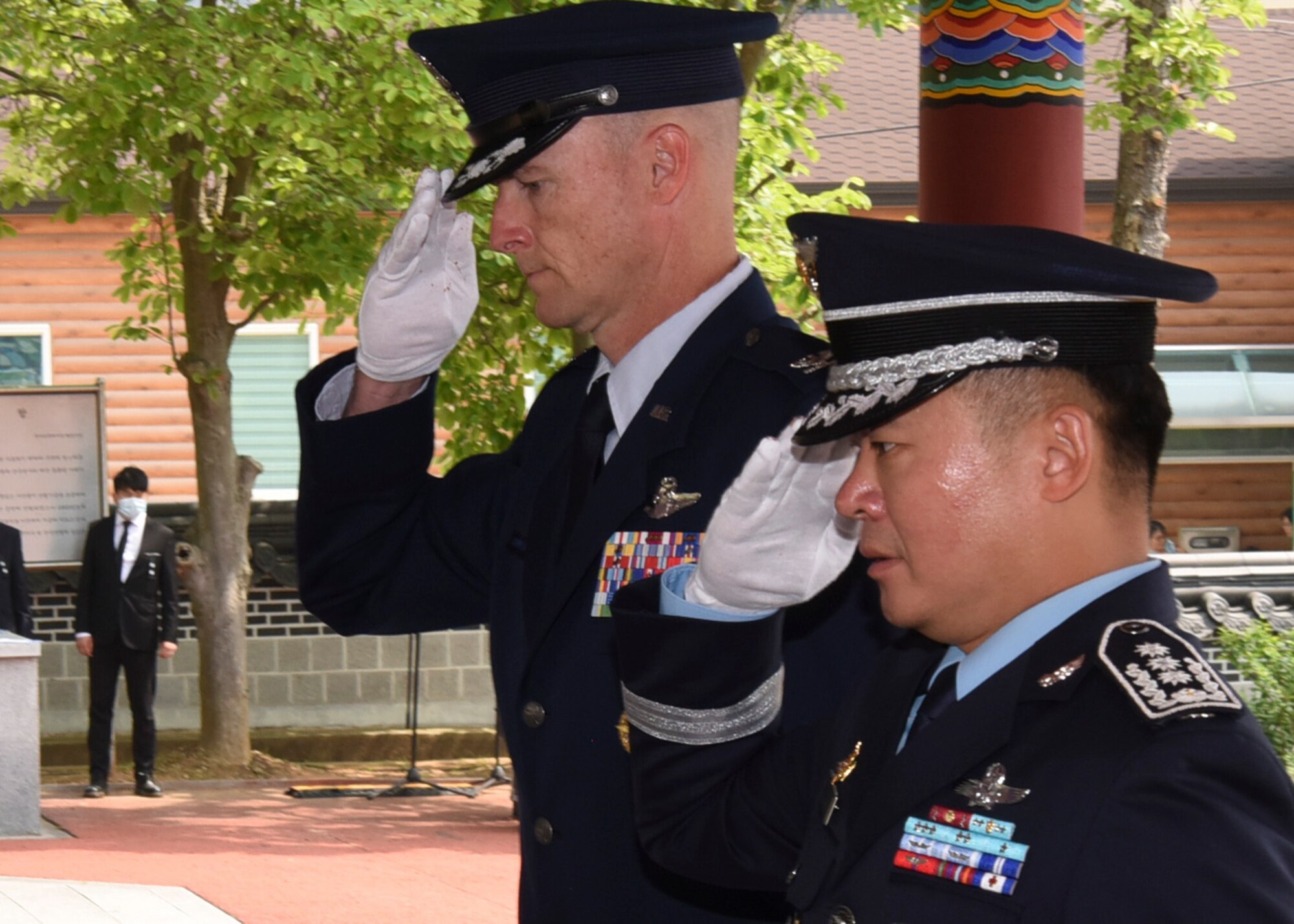 U.S. Air Force Col. Chris Hammond, 8th Fighter Wing commander, and Republic of Korea Air Force Col. Jung-Soo Kim, 38th Fighter Group commander, salute in respect to the Korean citizens who died while serving in the military or during the independence movement while attending the Korean Memorial Day ceremony at Gunsan City, Republic of Korea, June 6, 2020. The Korean citizens who died while serving in the military and those who lost their lives during the independence movement were honored with white carnations during the ceremony while flags and flowers were displayed at each headstone. (U.S. Air Force photo by Staff Sgt. Anthony Hetlage)