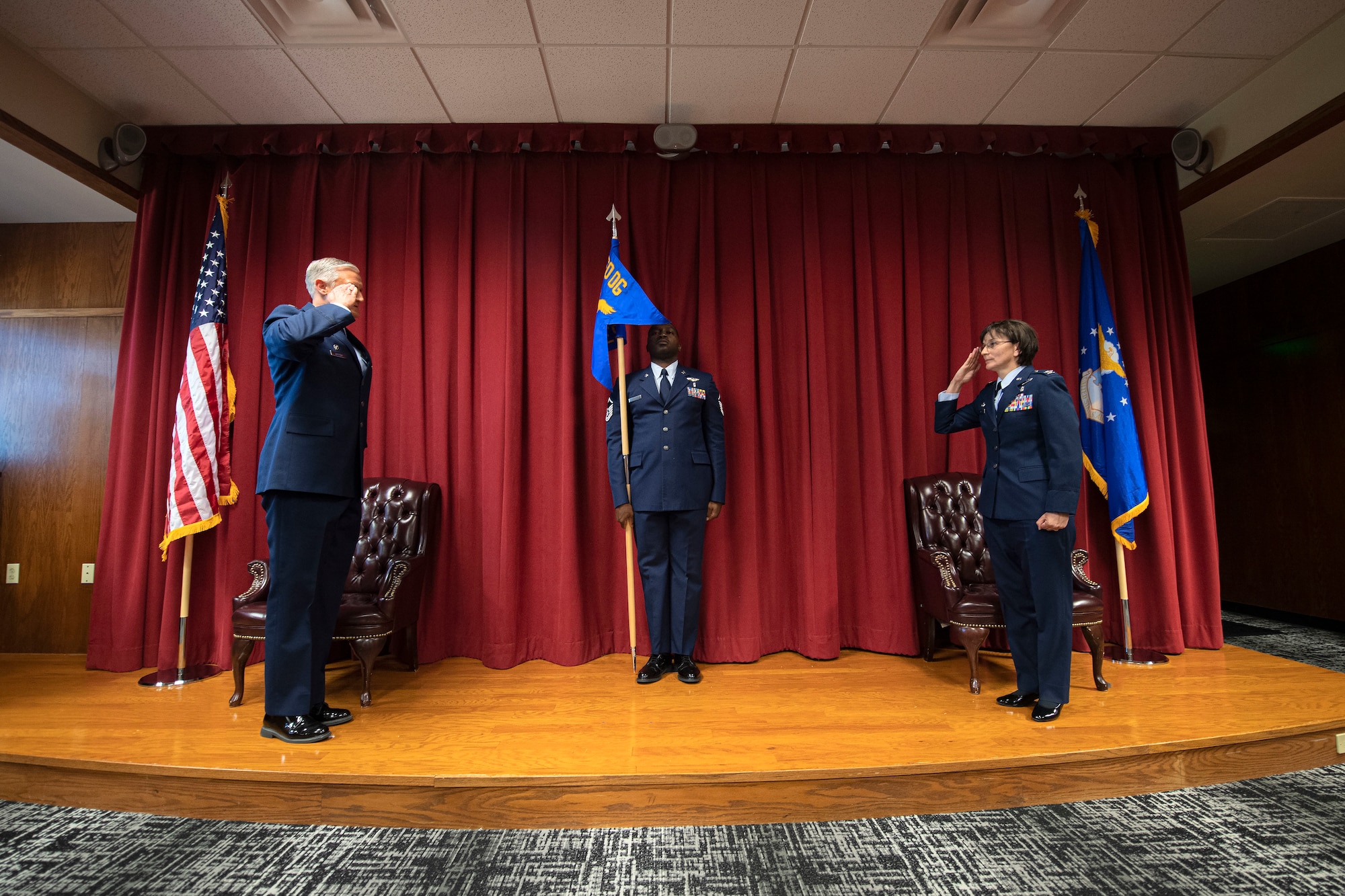 U.S. Air Force Col. Suzie Dietz, incoming 60th Aeromedical Evacuation Squadron commander, right, assumes command of the 60th AES from Col. Gregg Johnson, 60th Operations Group commander, left, while Master Sgt. Ryan Wallace, 60th AES acting superintendent, holds the guidon June 9, 2020, at Travis Air Force Base, California.
