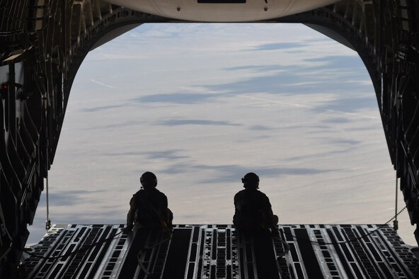 Master Sgt. Anthony Leonard and Staff Sgt. Jason Conner, 7th Airlift Squadron loadmasters, sit on the end of an open cargo bay of a C-17 Globemaster III over the Nevada Test and Training Range, Nev., June 6, 2020. As part of a joint force exercise designed to improve readiness, ten C-17s conducted a simulated air drop mission over the Nevada Test and Training Range. (U.S. Air Force photo by Airman 1st Class Mikayla Heineck)