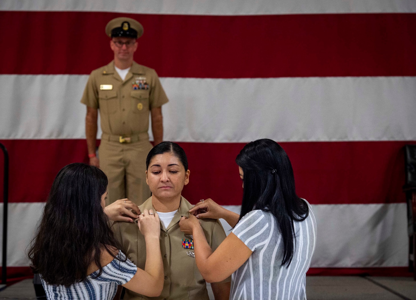 U.S. Fleet Forces Command (USFFC) 2019 Sea Sailor of the Year (SOY) Chief Aviation Structural Mechanic Carolina Berrio, of Strike Fighter Squadron (VFA) 81 and an Armenia, Columbia native, center, is pinned by her daughter and sister during a chief pinning ceremony at the Center for Naval Aviation Technical Training hangar onboard Naval Air Station Oceana, June 2, 2020.