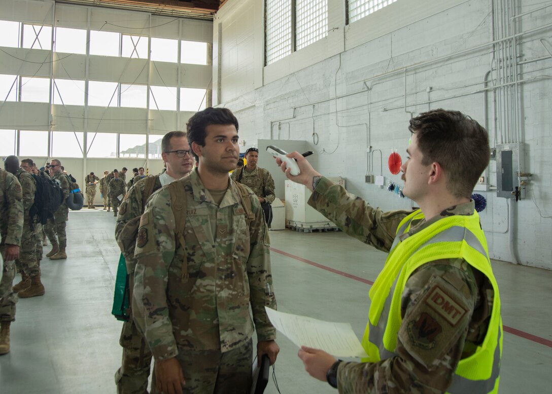 U.S. Air Force Staff Sgt. Zachary Reynolds, 366th Operational Medical Readiness Squadron independent duty medical technician, scans the temperature of Airmen of the 389th Fighter Squadron returning Airmen, June 3, 2020, at Mountain Home Air Force Base, Idaho. The temperature check is for pre-COVID-19 screening which is part of the re-integration process. (U.S. Air Force photo by Airman 1st Class Akeem K. Campbell