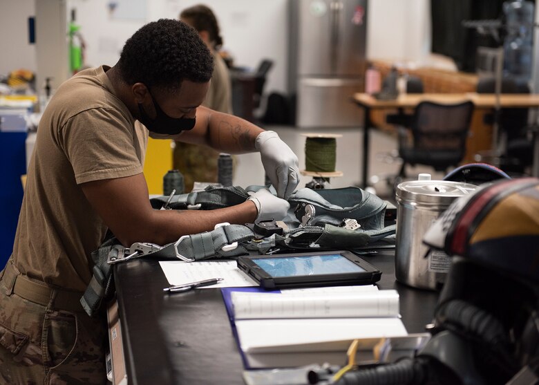 An Airman inspects a harness.