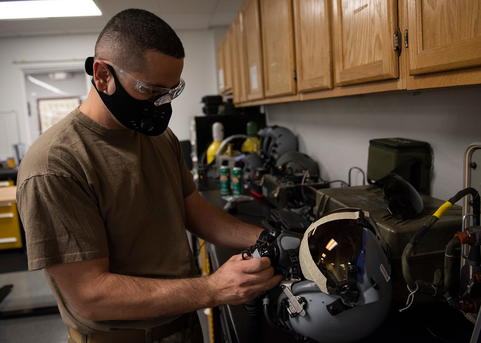 An Airman works on a fighter pilot helmet.