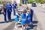 Nurses receive a package of treats from children in front of a hospital