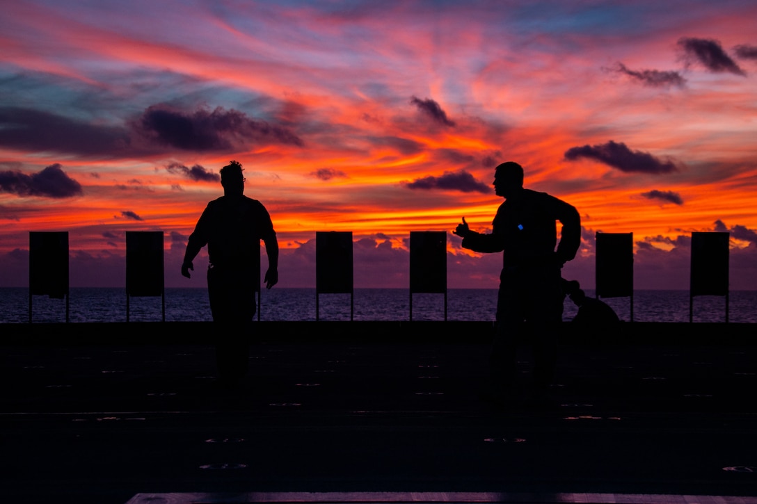 A U.S. Marine talks with a Sailor aboard amphibious assault ship USS America (LHA 6) prior to a live fire exercise aboard the America, April 20.