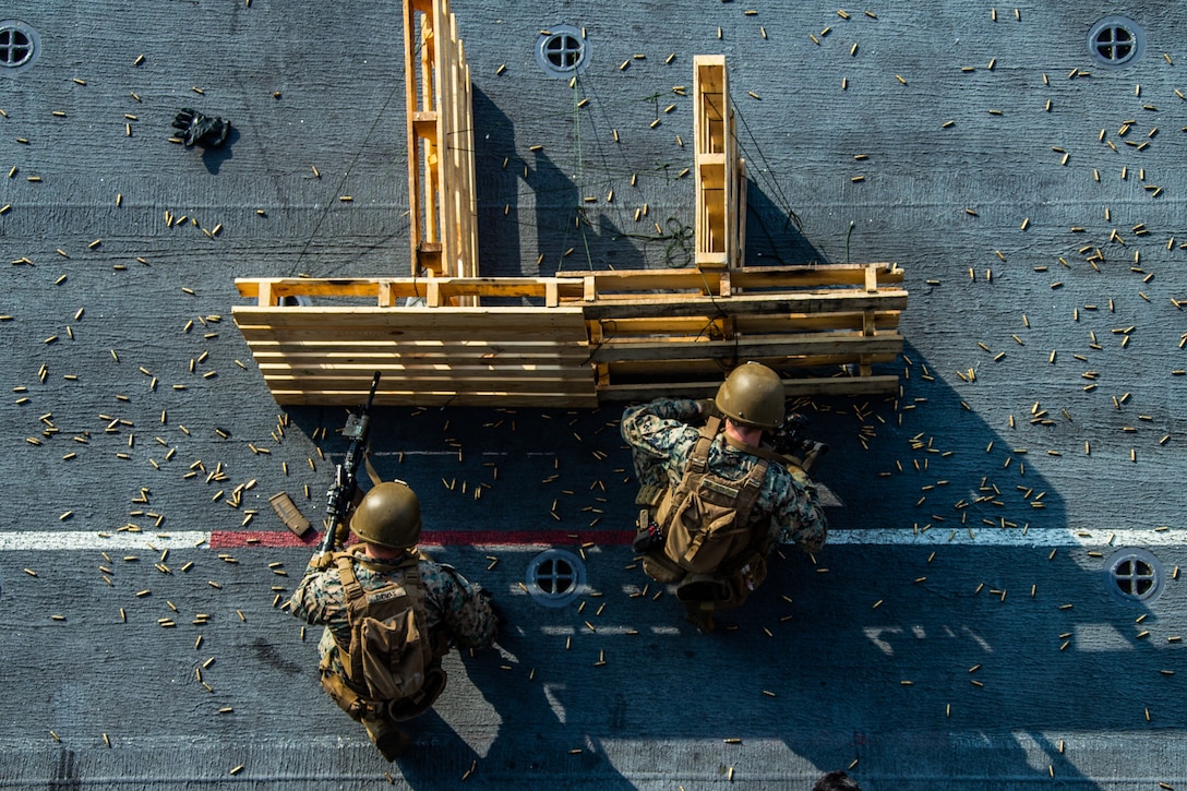 U.S. Marines fire M4A1 service rifles during a fast rope and deck shoot rehearsal aboard amphibious assault ship USS America (LHA 6), April 15.