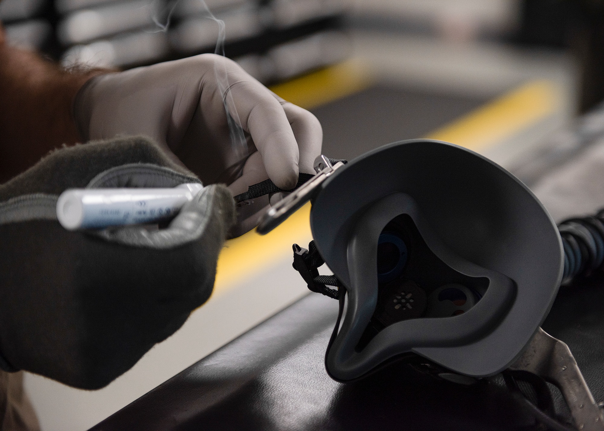 An Airman wearing gloves cauterizes an oxygen mask.