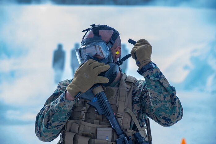 A U.S. Marine puts on his M50 protective mask during a Combat Marksmanship Program live-fire range in Setermoen, Norway, April 14.