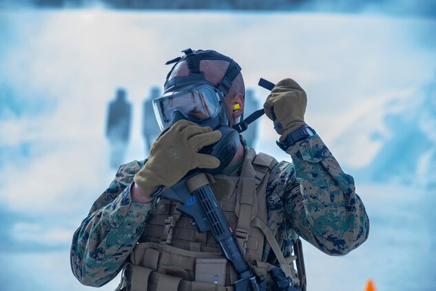 A U.S. Marine puts on his M50 protective mask during a Combat Marksmanship Program live-fire range in Setermoen, Norway, April 14.