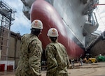 Rear Adm. Stephen Evans, left, commander of Carrier Strike Group (CSG) 2 and Rear Adm. Sara A. Joyner, right, take a tour of the aircraft carrier USS George H.W. Bush (CVN 77).