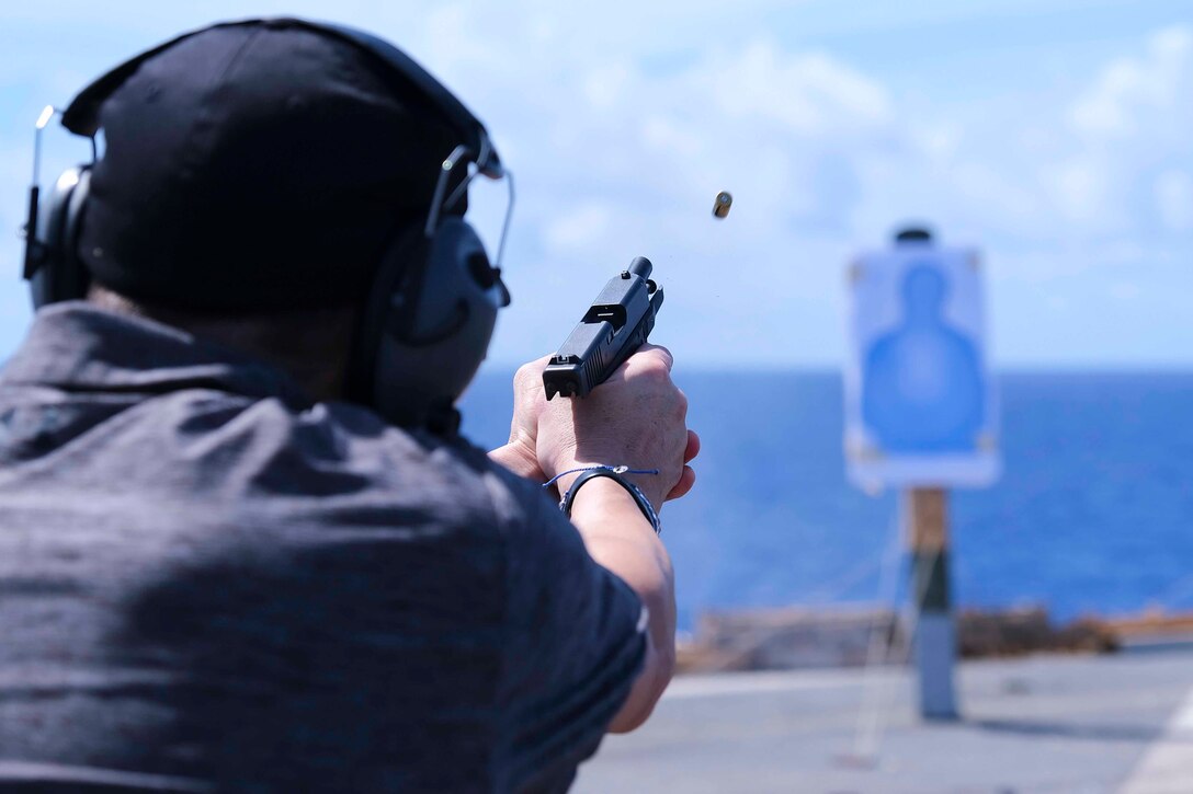 A man fires a handgun at a target.