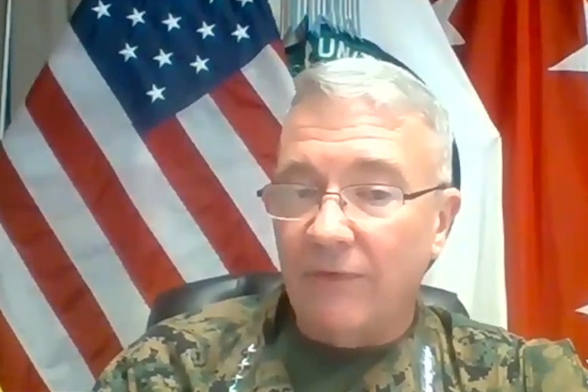A man in a military uniform speaks during a video conference.