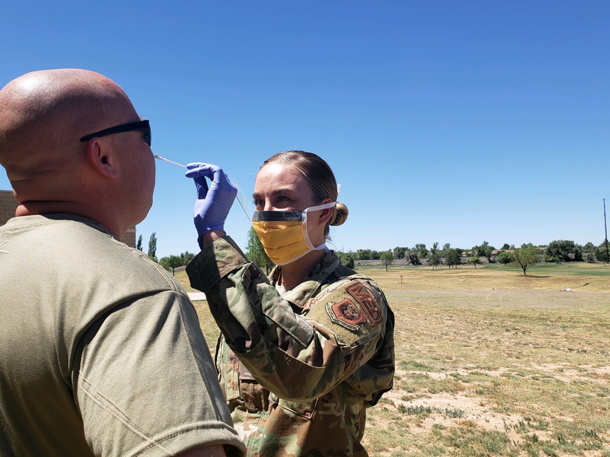 Airman 1st Class Sinead Brosnan, 27th Special Operations Medical Operations Squadron aerospace medical technician, takes a nasal swab of a deployer to test for COVID-19 before a deployment at Cannon Air Force Base, New Mexico, May 20, 2020. Over 100 nasal swabs were collected from deployers in order to meet theater requirements. (Courtesy Photo)