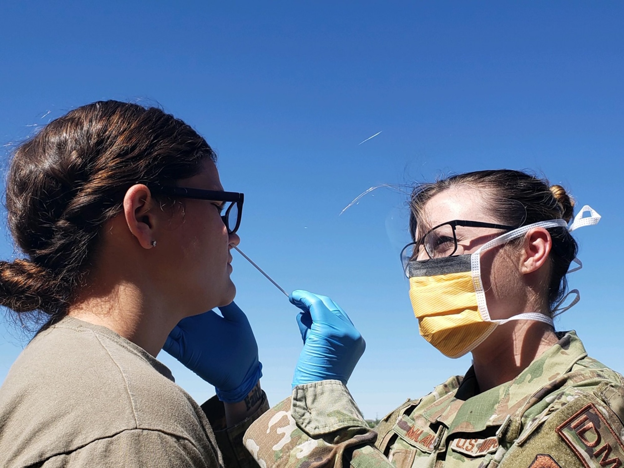 Staff Sgt. Ashley Malawey, 27th Special Operations Aerospace Medical Squadron aerospace medical technician, takes a nasal swab of a deployer to test for COVID-19 before a deployment at Cannon Air Force Base, New Mexico, May 20, 2020. After retrieving the nasal swabs, members of the 27th Special Operations Medical Group packaged and prepared the swabs for air transport to be delivered to Lackland Air Force Base, Texas. (Courtesy Photo)