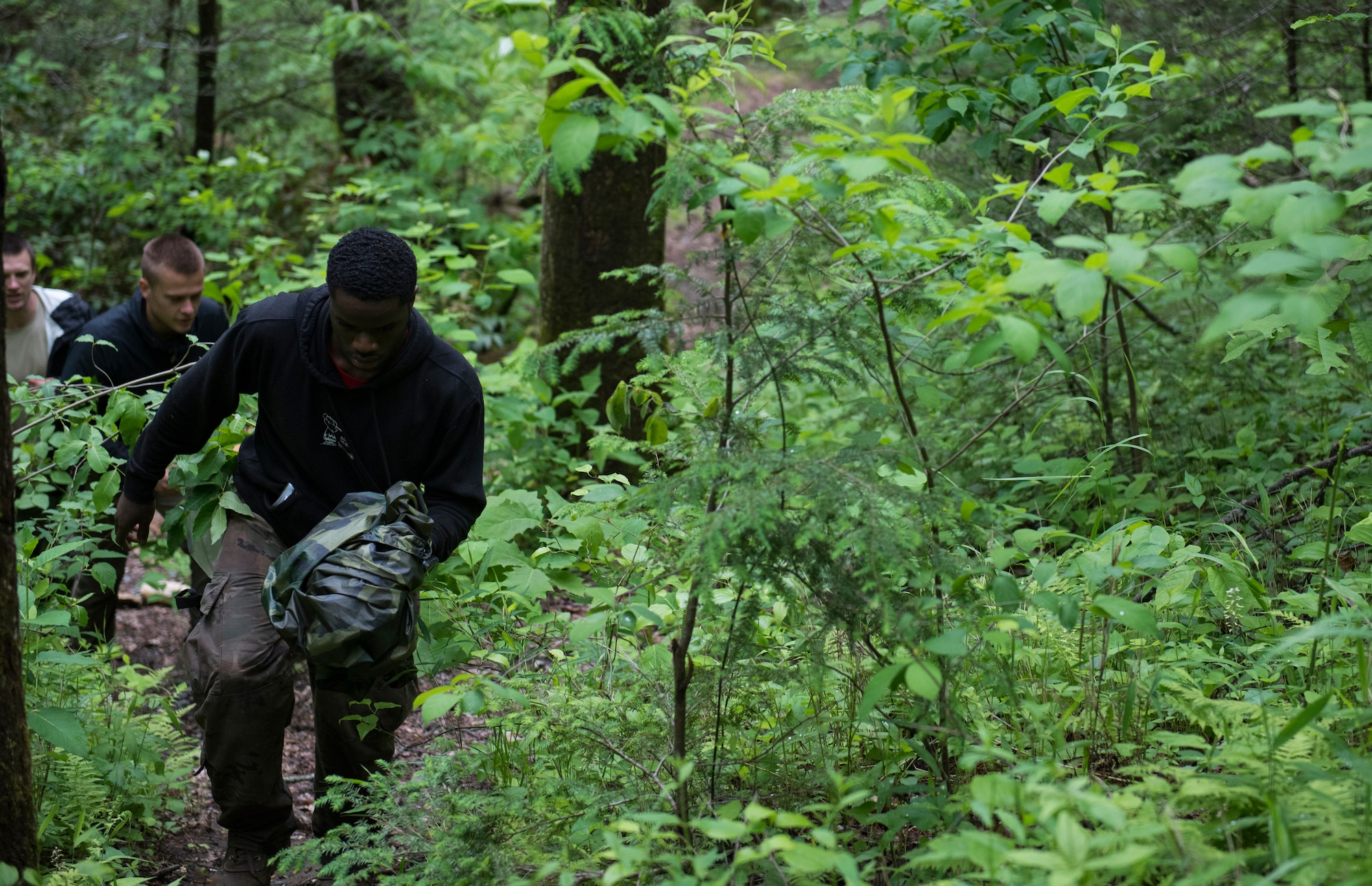 Airman 1st Class Omari Whiteside, 4th Munitions Squadron precision guided munitions crewmember, leads a group of Airmen up the side of a mountain during combat survival training, near Brevard, North Carolina, May 21, 2020. The training consisted of learning land navigation, living off of the land, creating shelters, evading hostile enemies and more. (U.S. Air Force photo by Senior Airman Kenneth Boyton)