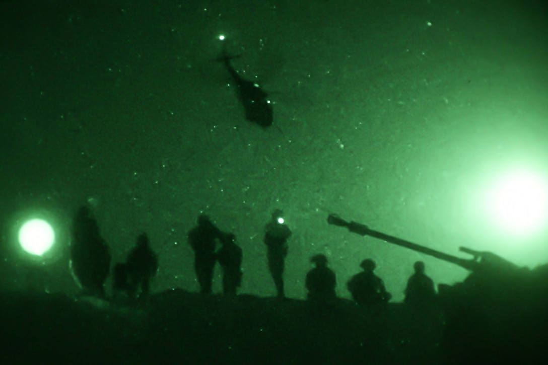 A U.S. Army UH-60 Black Hawk helicopter flies over U.S. Soldiers of the 1st Battalion, 5th Infantry Regiment, 1st Brigade Combat Team, 25th Infantry Division, at Al Asad Air Base, Iraq, May 29, 2020. Live fire exercises performed at night prepare Soldiers to operate in any lighting conditions. (U.S. Army photo by Spc. Derek Mustard)