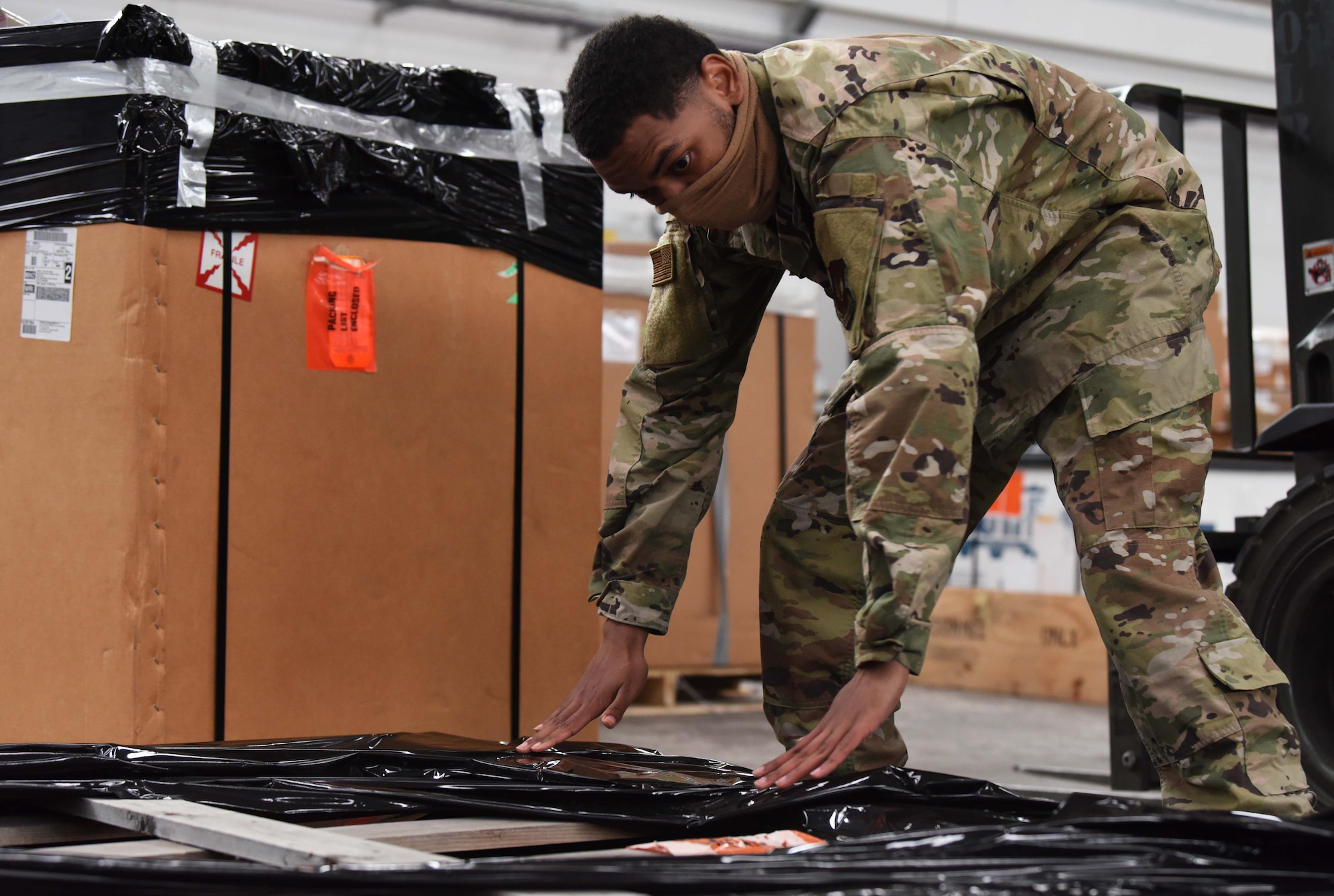 Airman 1st Class Malyk Wright, 100th Logistics Readiness Squadron packing specialist, prepares cargo for movement at RAF Mildenhall, England, June 8, 2020. The deployment and distribution within the traffic management office packages cargo, certifies inbound and outbound cargo and schedules deliveries. (U.S. Air Force photo by Senior Airman Brandon Esau)