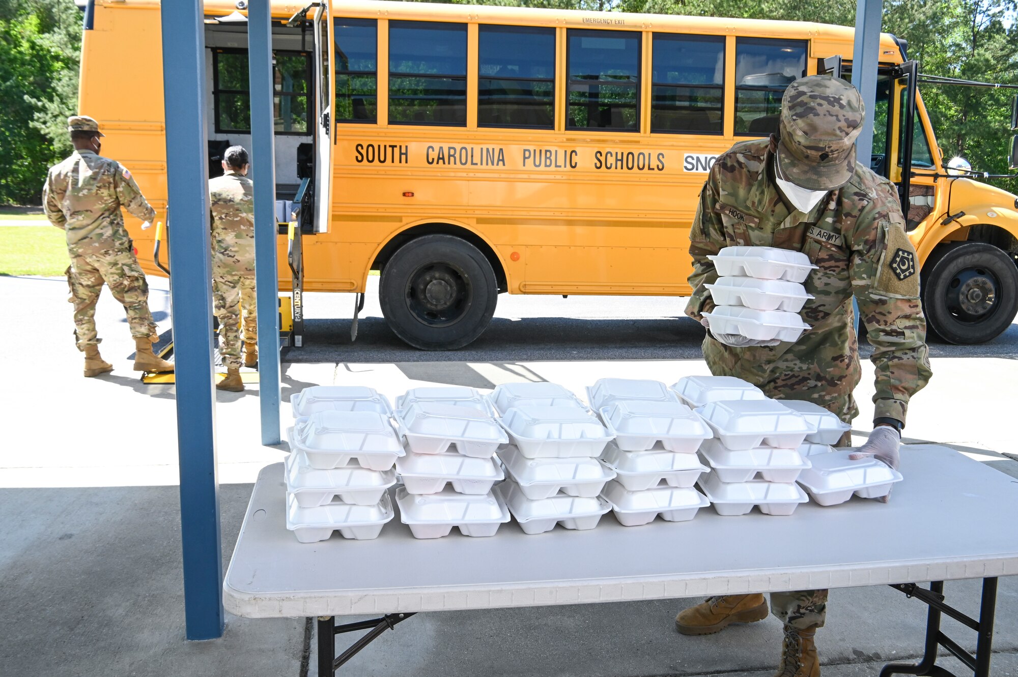 Soldiers load meals on school buses for COVID-19 response