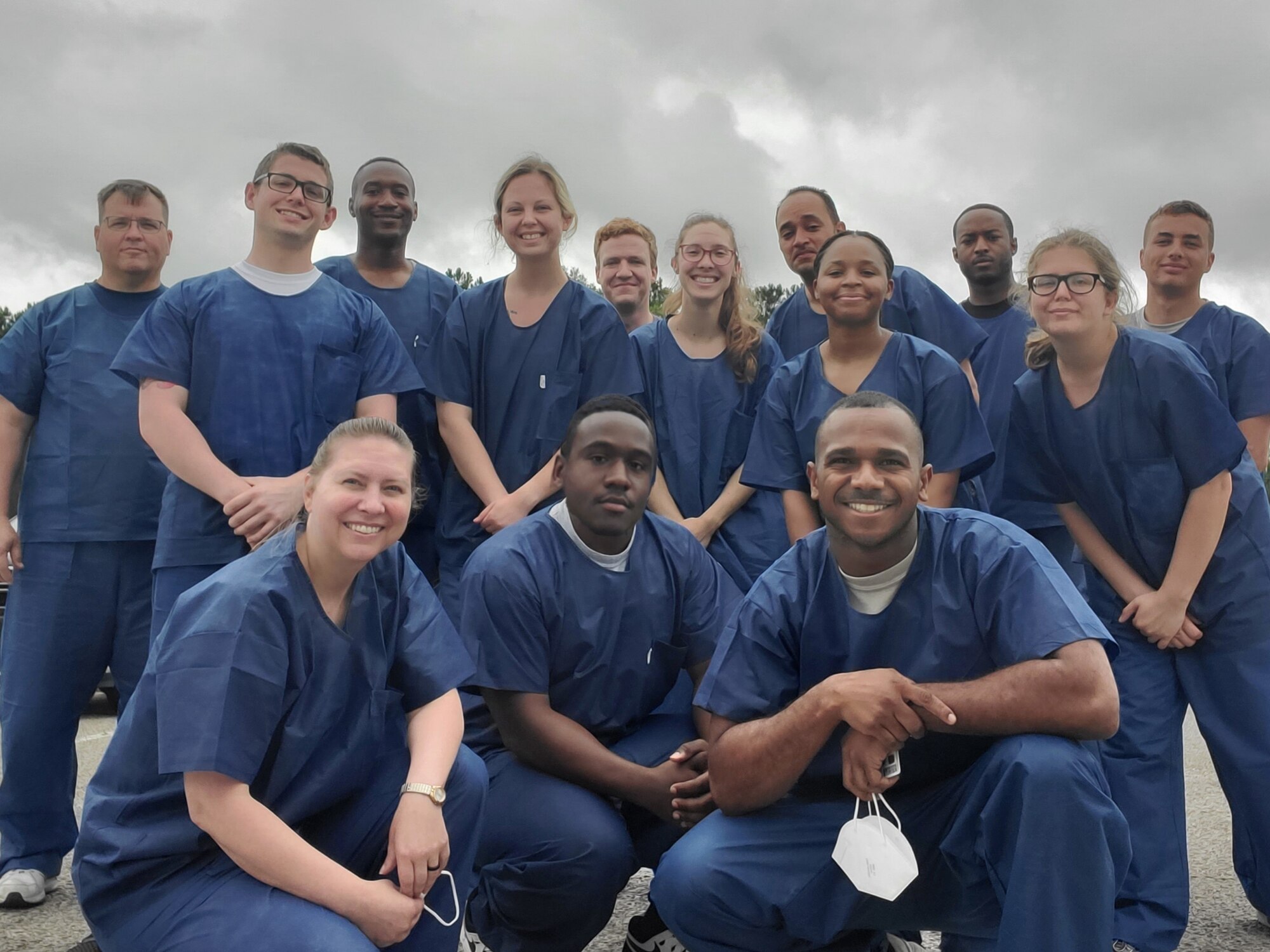 An Airman and several Soldiers pose in their blue medical garb after performing their mission at the Allendale Correctional Institution