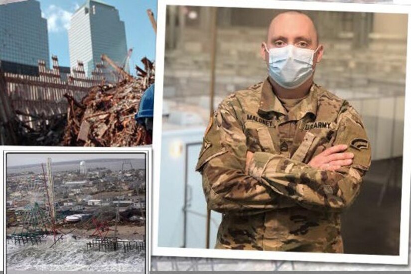 A soldier wearing a mask stands next to pictures of damage during September 11, 2001 and Hurricane Sandy.
